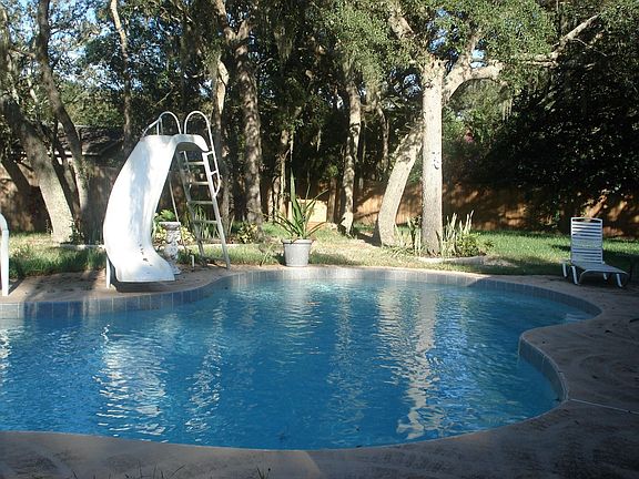 Lagoon style pool recently resurfaced and backyard has new fence