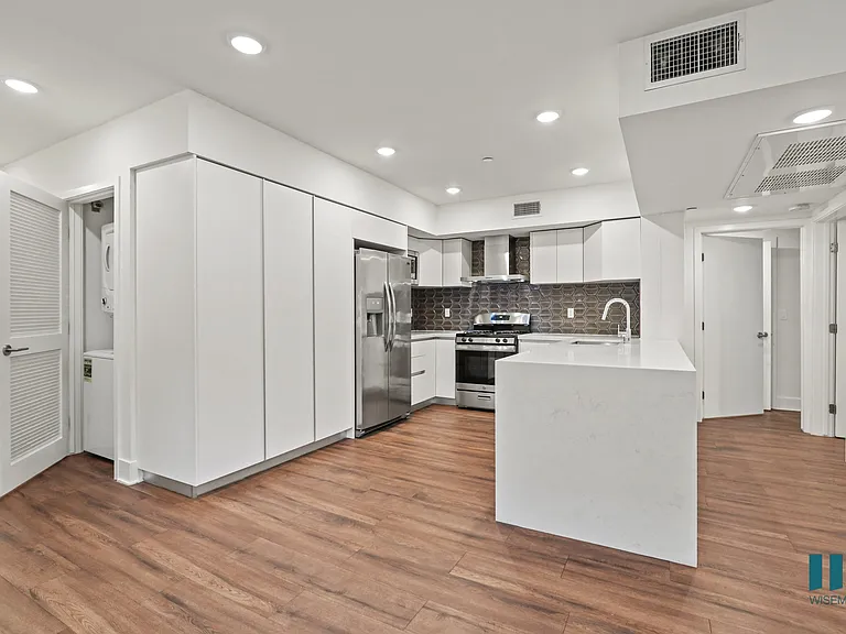 Kitchen with Energy-Efficient Appliances and Ample Cabinet Storage and Countertop Bar