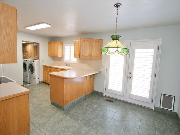 Kitchen, dining, laundry overview with french doors to back yard