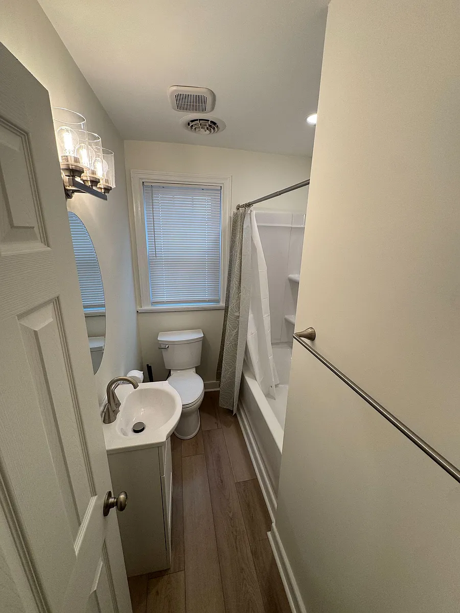 Full bathroom with tub/shower combo, window with blinds, and vanity lighting for comfortable daily routines. - Fourqurean Ln