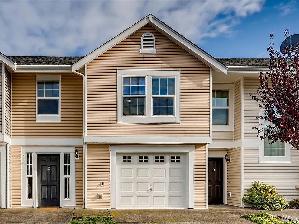 Front of the townhome with main entry door and one car garage to the right. 