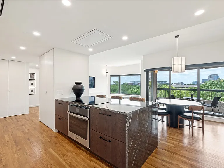 This unit offers an unimpeded perfect flow for entertaining and everyday living. Note the double-door closet next to the island has floor-to-ceiling shelving while the cabinets to the far left offer both shelving and space for cleaning appliances and supp