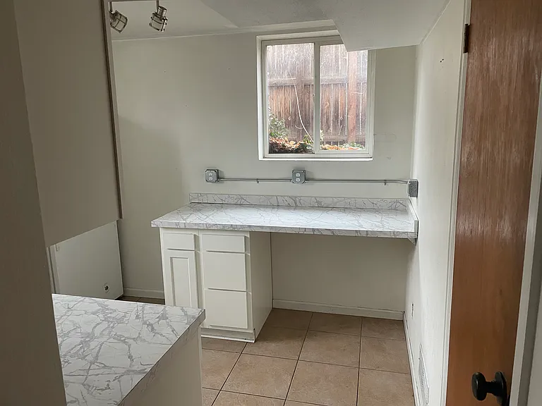 Kitchen desk (many electrical outlets), eating space and extra counter space with large pantry (pantry door seen to the right)