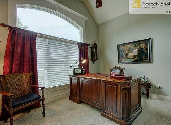 Main floor office/bedroom with focal window and vaulted ceilings