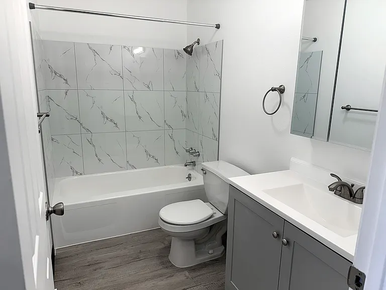 Beautifully renovated bathroom with a mirror medicine cabinet for extra storage.