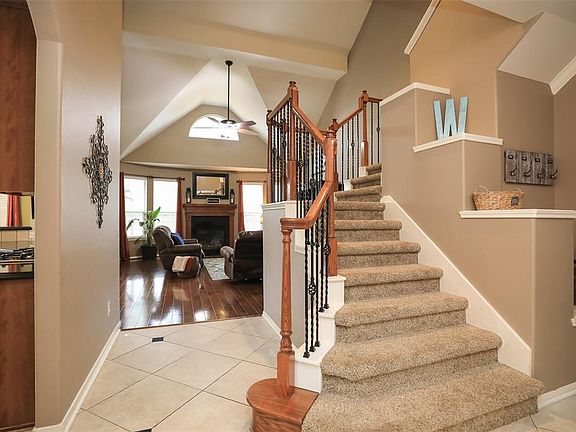 Cute storage and display areas trimmed out with molding. Iron staircase with wood bannister.