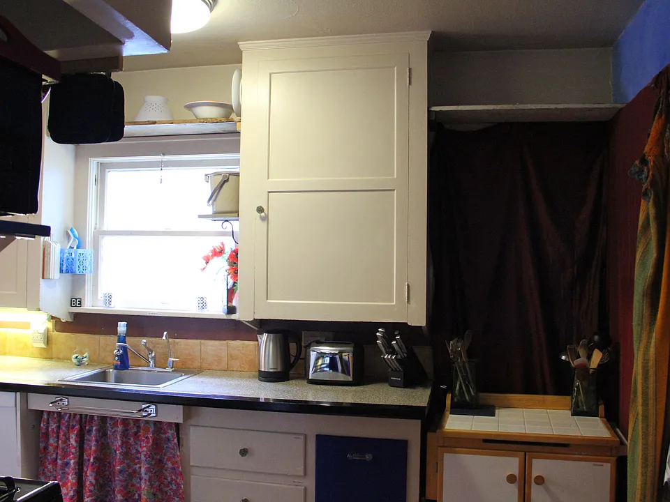 Kitchen angle with kitchen sink & full sized washer/dryer to the right. To replace photo with better lighting.