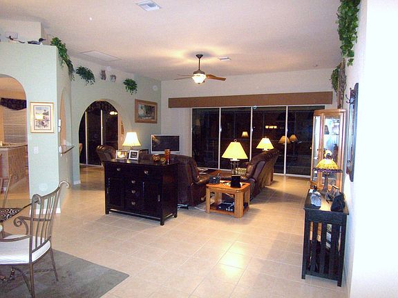 View from ft=ront door showing hi ceiling w.plant shelves & pocketing slider.