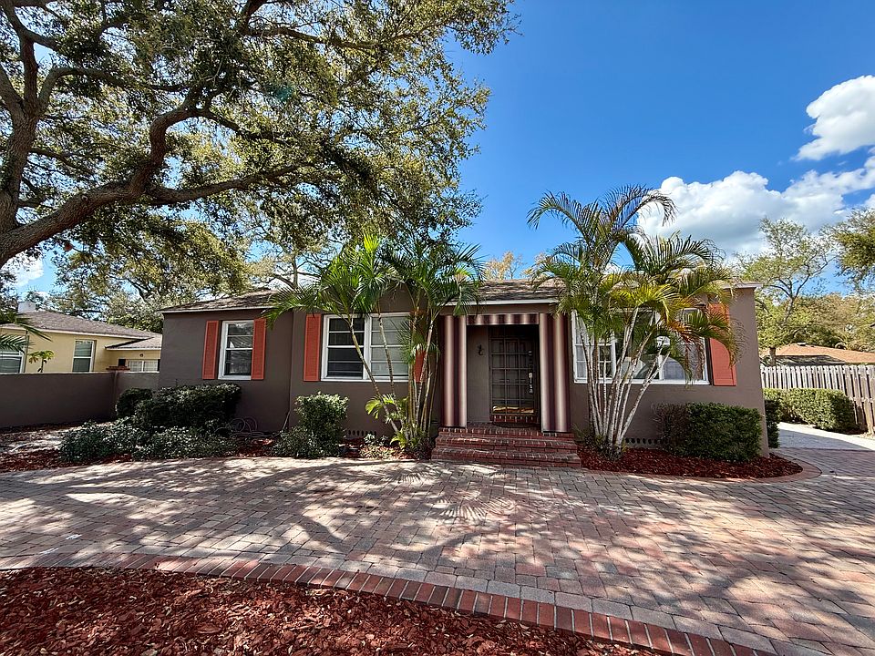 Property front with circular driveway and additional parking on side.