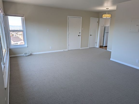 view of living room to front door, hall closet, eating nook and then kitchen