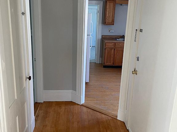 Entranceway looking into kitchen with front door on the right and entrance to living room on left.