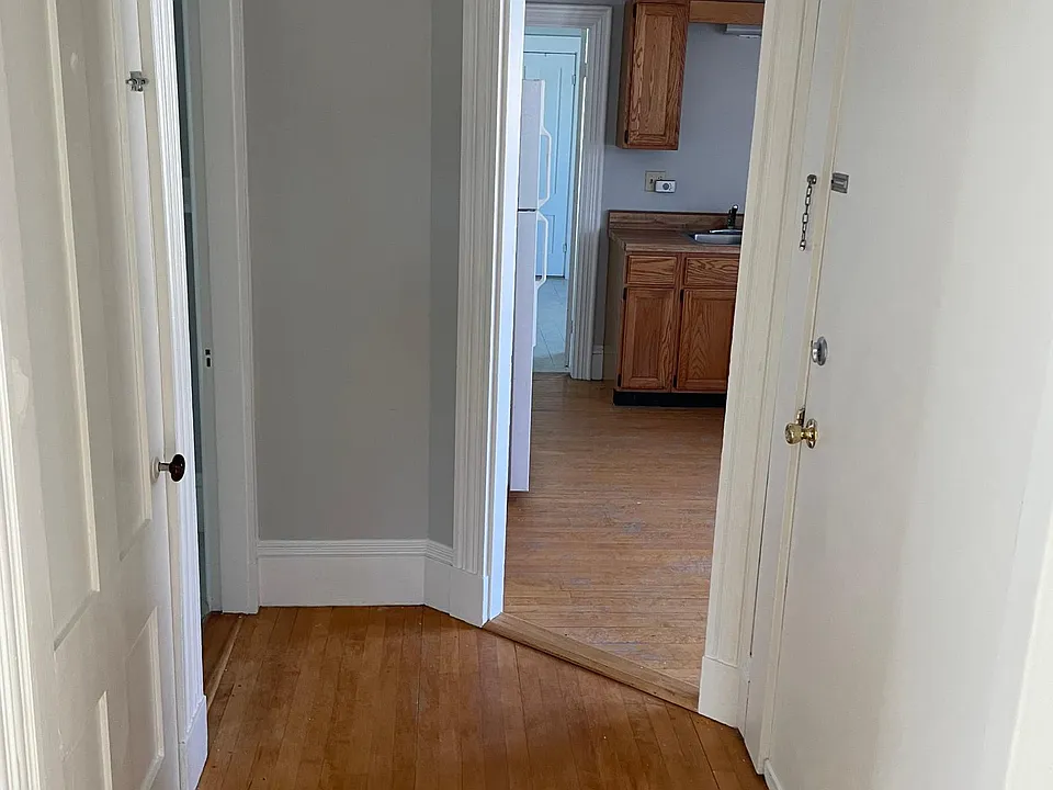Entranceway looking into kitchen with front door on the right and entrance to living room on left.