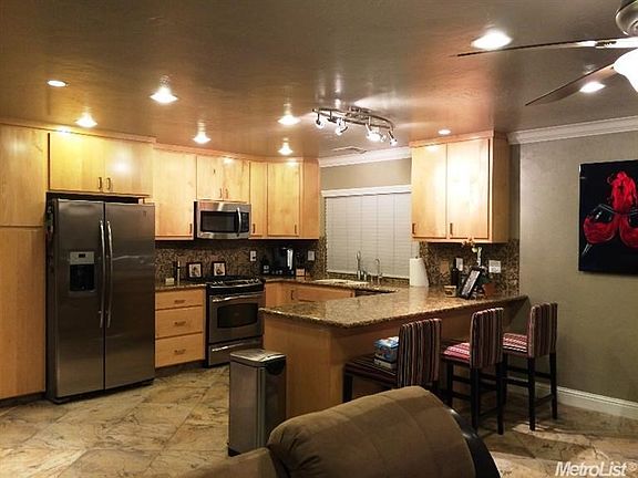 Remodeled kitchen with birch cabinets, granite counters and stainless steel appliances. 24" tiles
