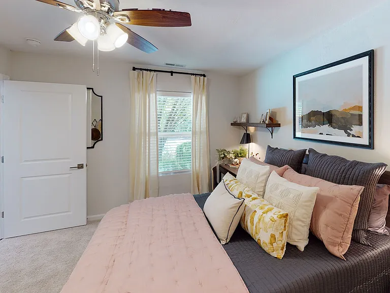 Relax in a bright and airy bedroom with soft natural light and modern ceiling fan at The Preserve Murfreesboro.