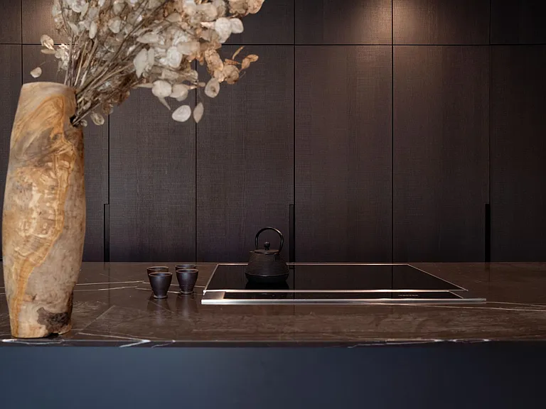 Sleek Gourmet Kitchen with Seamless Custom Cabinetry _ Designed for both aesthetics and functionality, this kitchen features a striking dark wood-paneled backdrop, integrated Miele appliances, and a refined stone island.