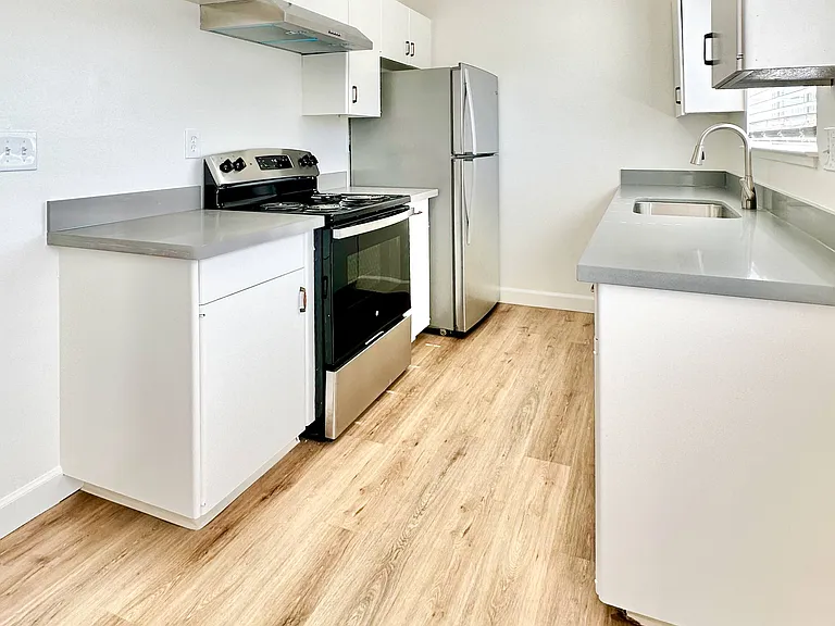 a kitchen with white cabinets and a stove and a refrigerator
