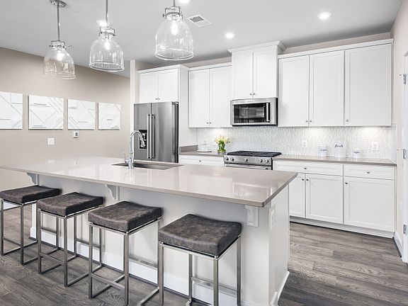 Model RepresentatiWhite Cabinetry with Stellar Gray Quartz Counters in the Ethan Kitchen at the Metr