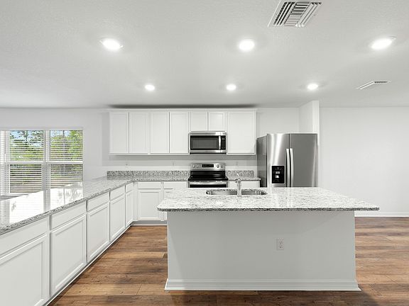 The kitchen has beautiful white cabinets