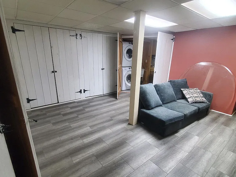 Downstairs room with storage, laundry, utility room. Can be used as a family/TV room, office, gym. Not suitable as a bedroom due to size of the windows.