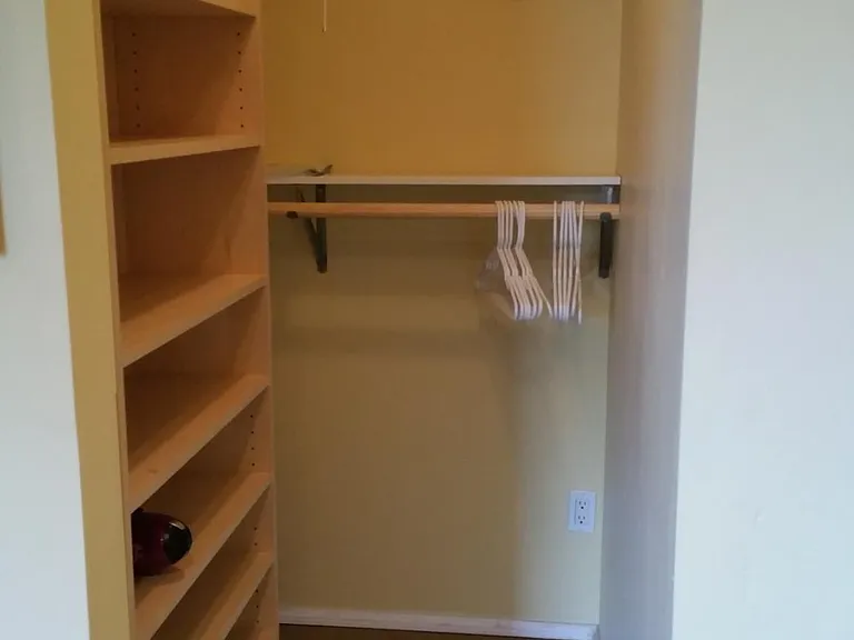 Walk-in closet that extends further to the left on the clothes hangers.