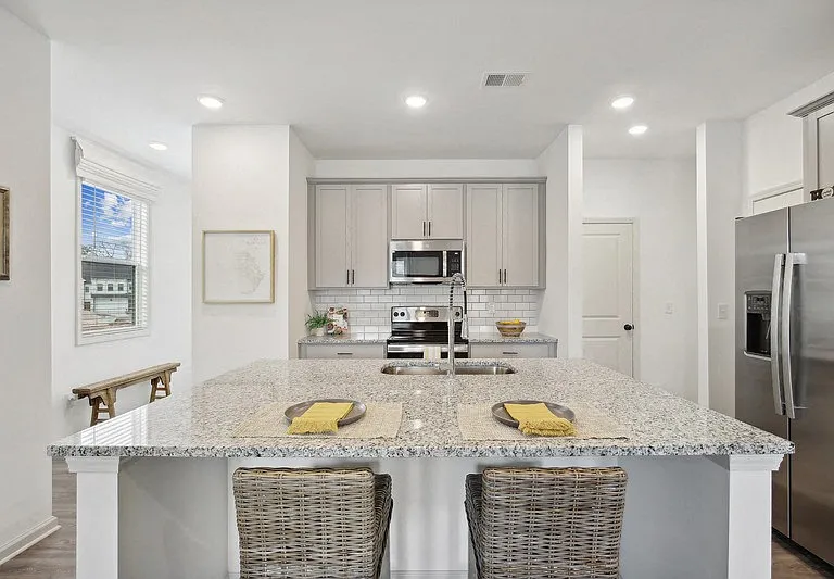 View of the kitchen and entry hallway. Offering bar seating, plenty of cabinet space and granite countertops.