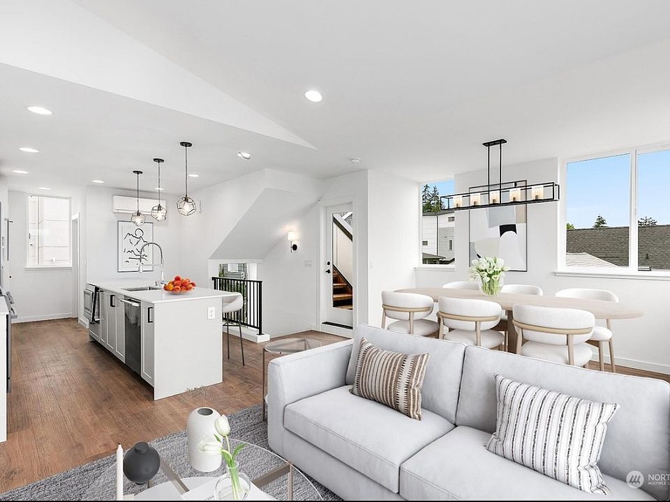Living room/Dining room/Kitchen on top floor with water views, Ballard bridge and evergreen trees outside the windows. Plentiful of natural light.