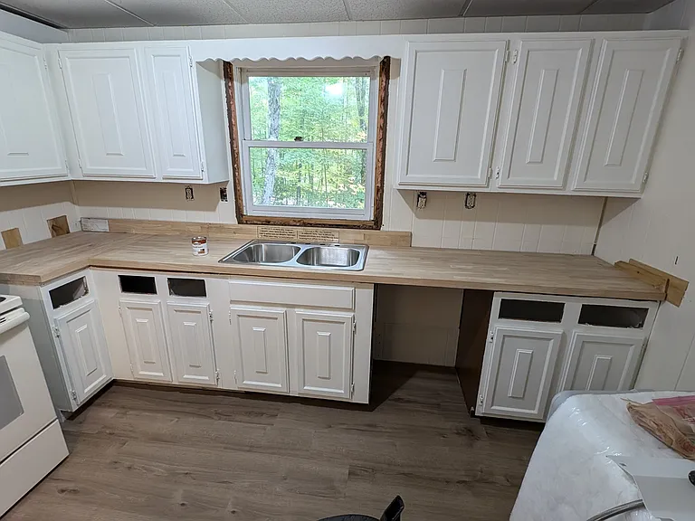 Kitchen, mid-construction. New range, dishwasher, and butcher block counter.