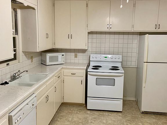 Large, bright kitchen with stove, refrigerator and dishwasher