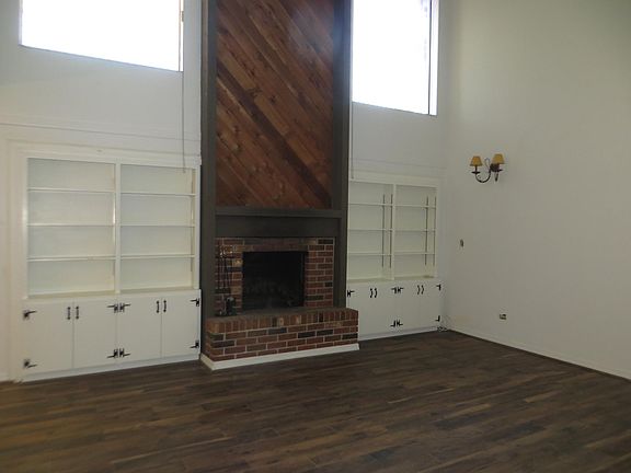 Spacious living room with wood burning fireplace with bookshelves