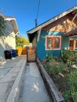 Entrance at side of house through gate into backyard. Apt has its own address and mailbox in front.