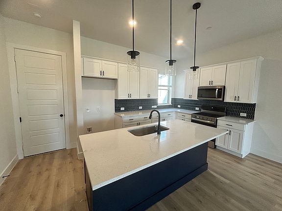 Kitchen: Large island, stainless steel appliances, sleek finishes.