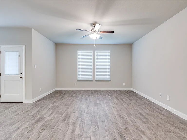Empty room with ceiling fan and light hardwood / wood-style floors