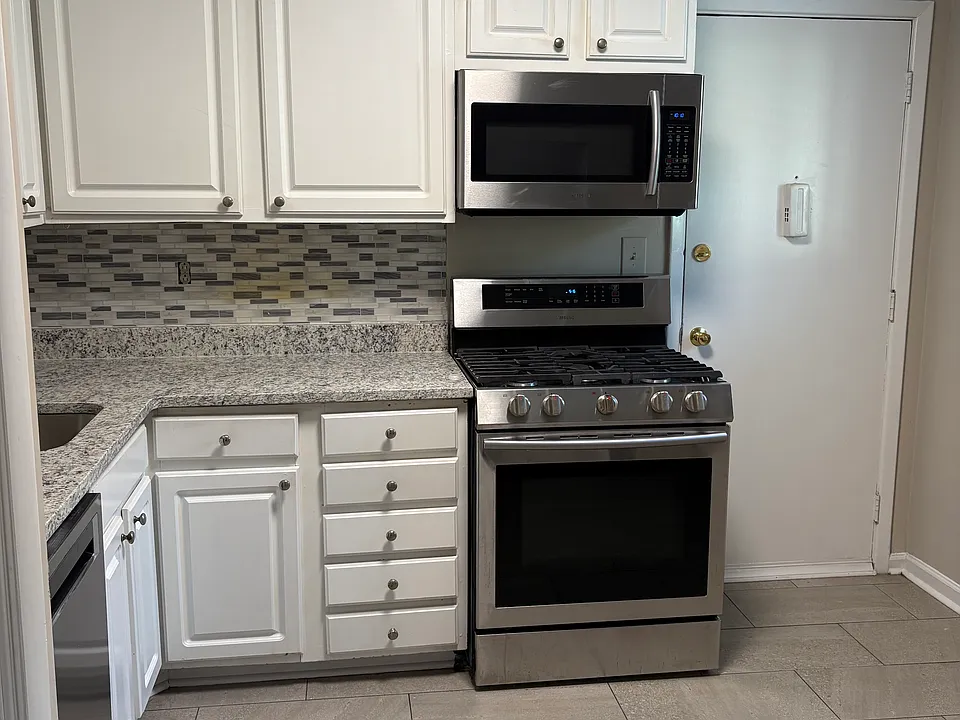 Kitchen with new granite counters and pull down sprayer faucet. Gas stove, microwave vent, dishwasher and refrigerator all stainless steel.