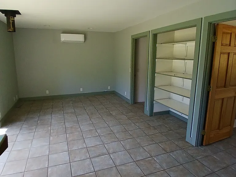 from the kitchen towards the bath, near door to bedroom, far door to bath/laundry combo