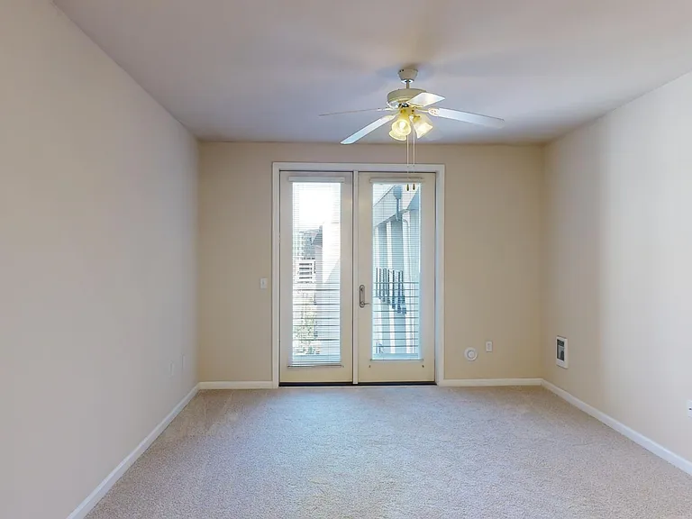 Apartment living room with plush carpet flooring.
