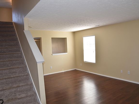 living room features hardscraped laminate flooring and pass through window to dining area