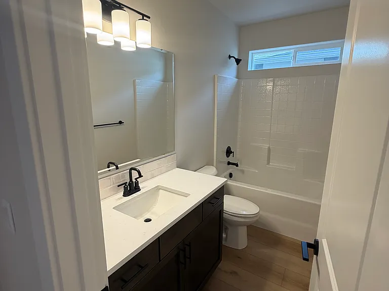 The bathroom showcases modern finishes, abundant lighting, and generous storage solutions. Its bright, inviting atmosphere and updated fixtures provide both comfort and practicality for daily living.
