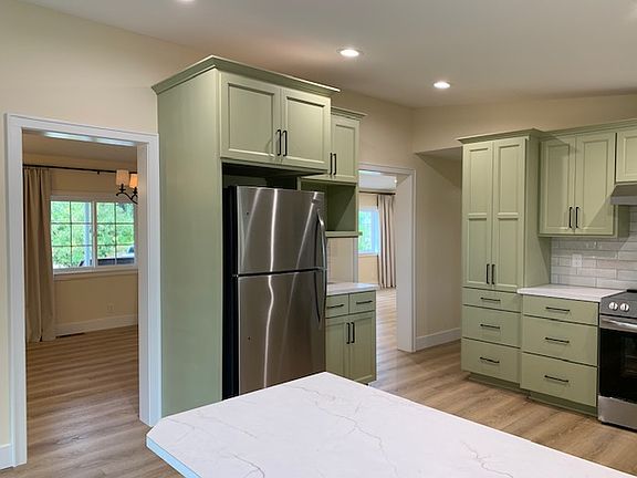 Kitchen with doorways to dining room, front room, and hallway/utility room.