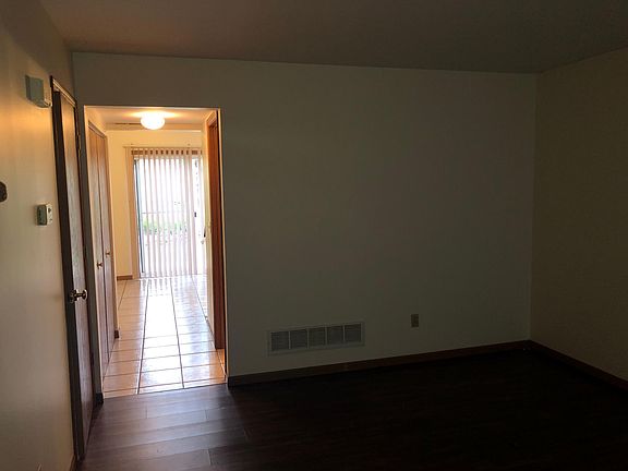 living room with storage under stairs/ then kitchen