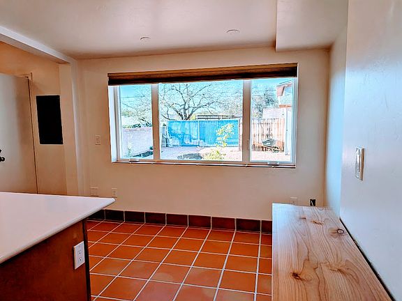 Dining area with large picture window; newly planted backyard draws birds and butterflies, mountain view