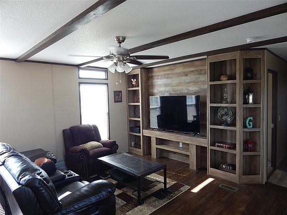 Built-in entertainment center has look of reclaimed wood plank wall.  Seller leaving this 60" TV for new owner's enjoyment!