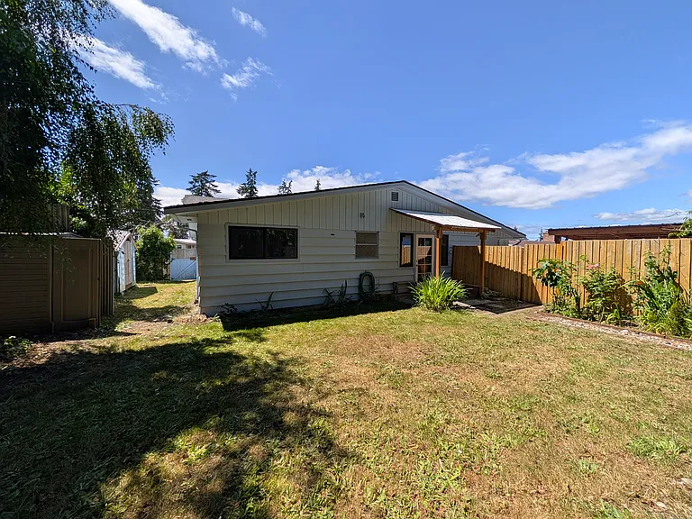Backyard looking at the back deck and fence dividing unit A from B