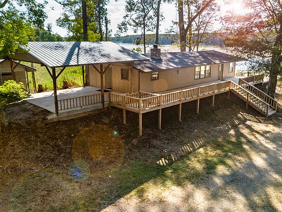 The Camp House! 3 bedrooms, 1.5 baths, kitchen, den, dining room, screened-in porch, and patio overlooking there water. Bonus, a covered storage room is perfect for gear off of the covered garage. And, a full deck with fenced in dog area located on the front porch.