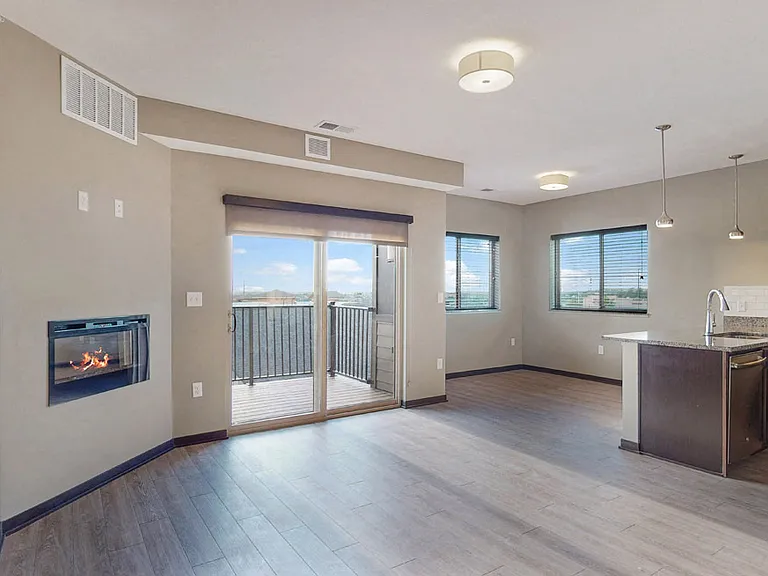 The 2 bedroom Snowdrop with den floor plan at WH Flats features natural light and a spacious dining and living area with electric fireplace.