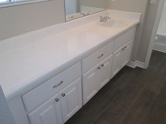 Newly renovated bathroom w/ white cabinets & white spray-lik
