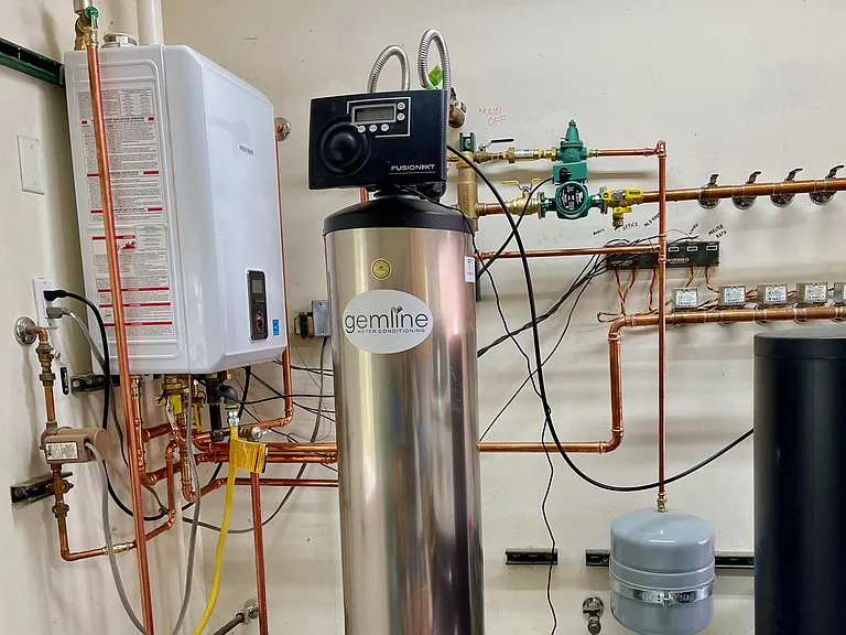 Tankless water heater/boiler for radiant in-floor heating and water softening system