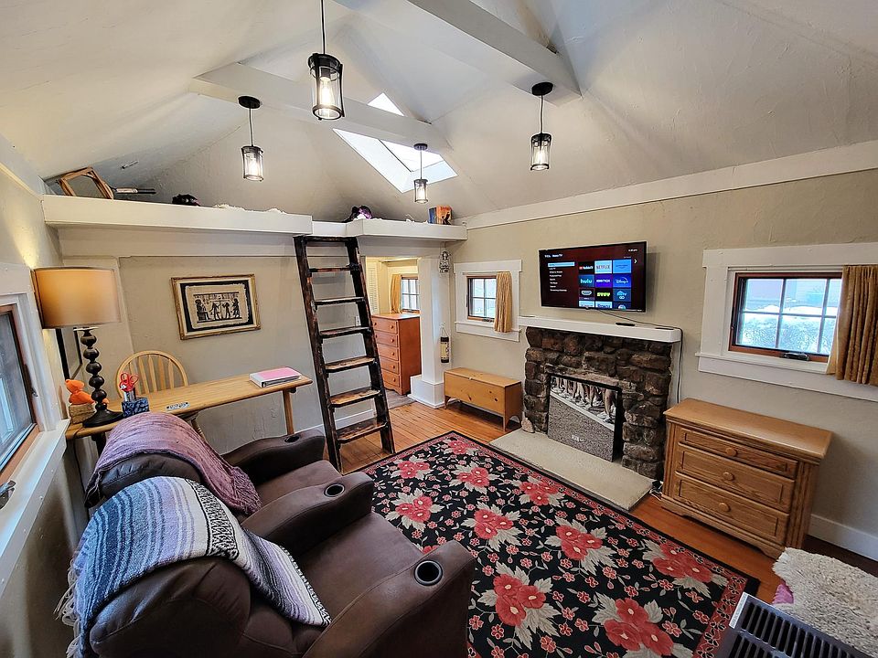 Fully furnished. Main entry room, TV, chairs, tall desk, small dresser.