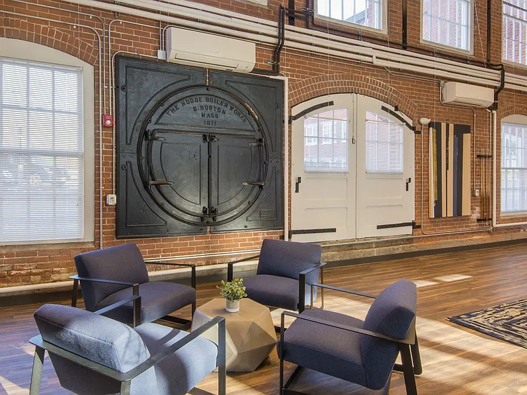Community Room With Lounge Area And Exposed Brick Walls.