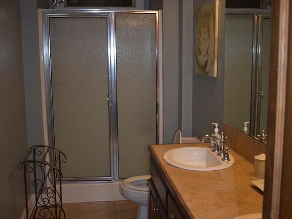 view of primary bathroom with walk in shower from large walk in closet.