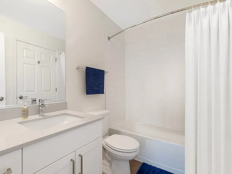 Renovated Package II bath with beige quartz countertop, white cabinetry, and hard surface flooring